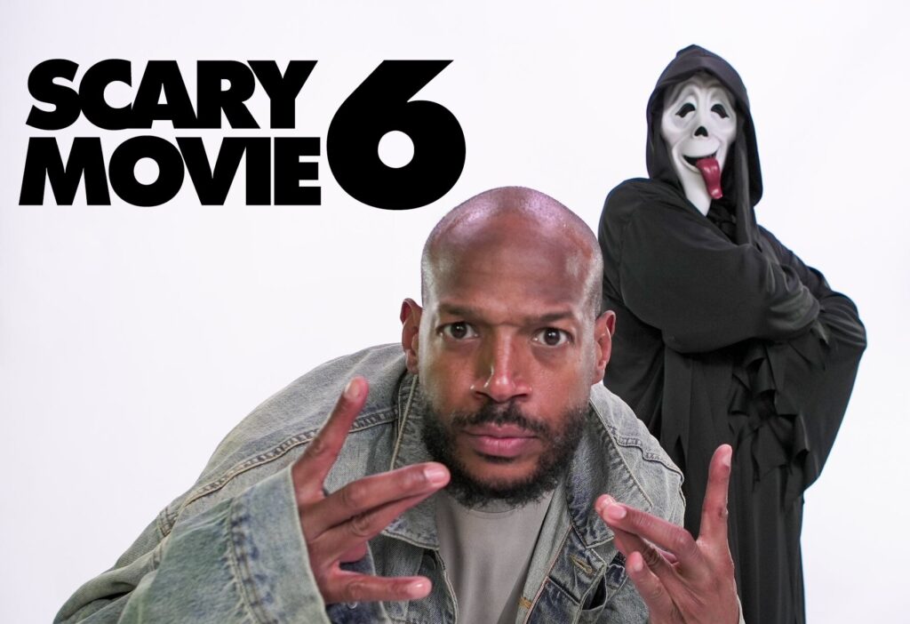 Man in a denim jacket making peace signs toward the camera, with a hooded masked figure in the background and large 'SCARY MOVIE 6' text on the left, suggesting a movie promo.