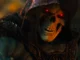 Skeleton in a dark hooded cloak with glowing red eyes, looming menacingly in shadows 11/2024 context-appropriate alt text