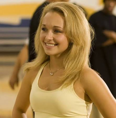 image | GotchaMovies Smiling blonde woman in a light yellow tank top at the gym.